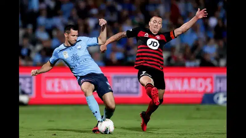 Cầu thủ của WS Wanderers chống chân trước cầu thủ của Sydney FC trong một tình huống tranh…